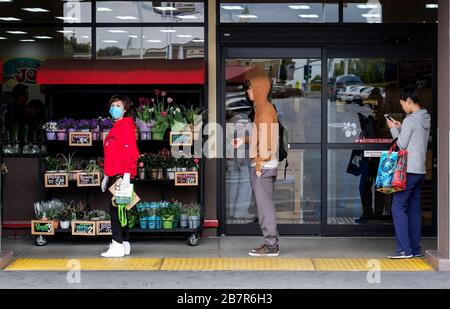 Los Angeles, Californie, États-Unis. 17 mars 2020. Les clients gardent la distance tout en attendant en ligne pour entrer sur le marché de Trader Joe le mardi 17 mars 2020, à Los Angeles, en Californie. Le gouverneur californien Gavin Newsom Sunday a appelé tous les bars californiens à fermer et à tous les aînés à s'isoler. De nombreux cinémas et autres lieux publics ont fermé leurs portes, tandis que d'autres entreprises restent ouvertes pour des affaires normales, comme la propagation de Coronavirus (COVID-19) continue. Crédit: Ringo Chiu/ZUMA Wire/Alay Live News Banque D'Images