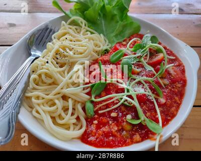 Les savoureux pâtes italiennes à spaghetti, appétissantes et classiques, avec sauce tomate, parmesan et basilic sur plaque Banque D'Images