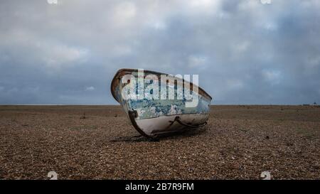 Dungeness est un promontoire du désert sur la côte du Kent en Angleterre. Vieux bateau de pêche isolé. Banque D'Images