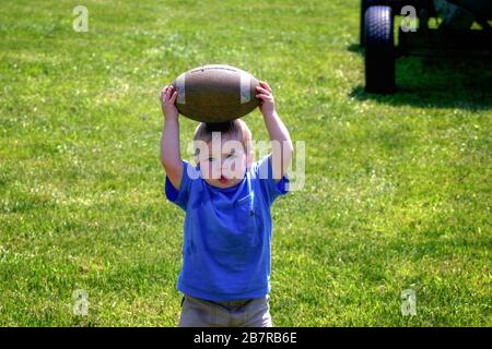 MEMPHIS, ÉTATS-UNIS - 21 avril 2007 : un très petit enfant tient le football sur sa tête. Prises à Canale Farms. Banque D'Images