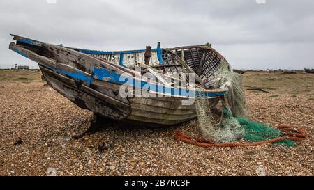 Dungeness est un promontoire du désert sur la côte du Kent en Angleterre. Vieux bateau de pêche isolé. Banque D'Images