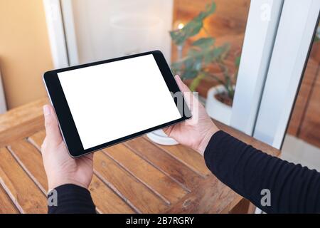 Image Mockup des mains tenant et regardant la tablette noire pc avec écran blanc vide Banque D'Images