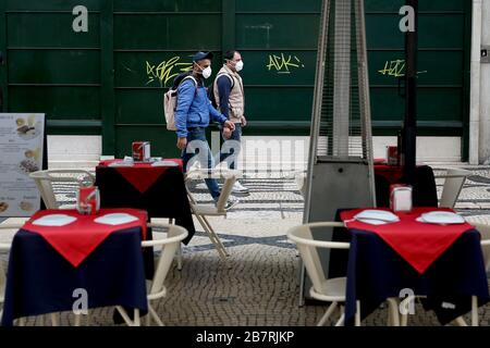 Lisbonne, Portugal. 17 mars 2020. Les piétons portant des masques de visage marchent près d'un restaurant vide dans le centre-ville de Lisbonne, au Portugal, le 17 mars 2020. Le Portugal a signalé 117 nouveaux cas d'infection à COVID-19 mardi, portant le nombre total de cas à 448, avec un décès. Crédit: Pedro Fiuza/Xinhua/Alay Live News Banque D'Images