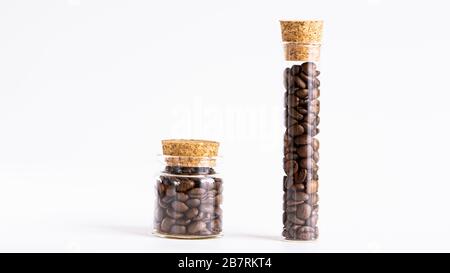 Grains de café torréfiés dans deux bocaux en verre.gros plan, isolé. Banque D'Images