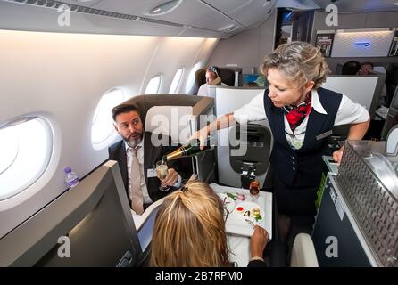 Johannesburg, Afrique du Sud - 06 Février 2014 : les membres de l'équipage de cabine de servir un verre de champagne en classe affaires d'un Airbus A380 Banque D'Images