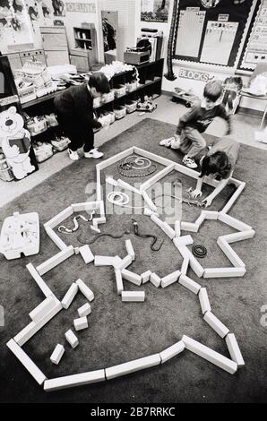 Austin Texas USA 1994: Les élèves de la maternelle travaillent ensemble dans une aire de jeu créative pour construire une enceinte pour les reptiles en plastique à partir de blocs de bois dans leur salle de classe à l'école élémentaire de Lake Travis. ©Bob Daemmrich Banque D'Images