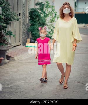 Femme et fille portant un masque facial jetable pour éviter l'infection virale. Protection contre le coronavirus Banque D'Images