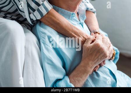 Vue réduite du couple senior qui tient les mains à la maison Banque D'Images