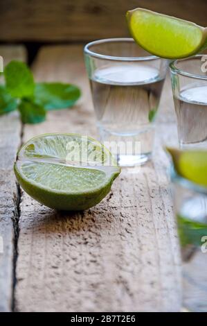 Boisson alcoolisée. Tequila argent avec citron vert sur la table en bois. Banque D'Images