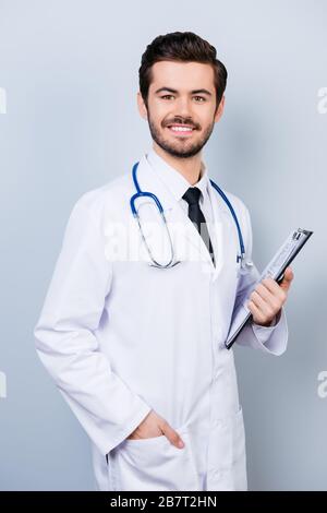 Portrait vertical du médecin souriant et réussi dans un presse-papiers uniforme Banque D'Images