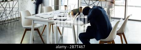 photo panoramique d'un homme d'affaires africain américain dormant sur une table au bureau Banque D'Images