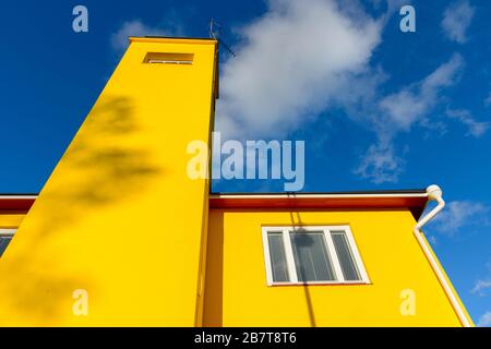 Bâtiment jaune avec fenêtres blanches contre vue sur le ciel bleu Banque D'Images