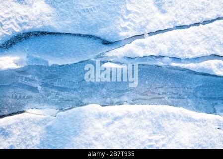 Des fissures de gros plan sur la glace recouverte de neige. Lac Baikal, Russie Banque D'Images