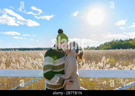 Joyeux jeune couple multiethnique embrassant et embrassant contre le beau champ de ruée d'automne Banque D'Images