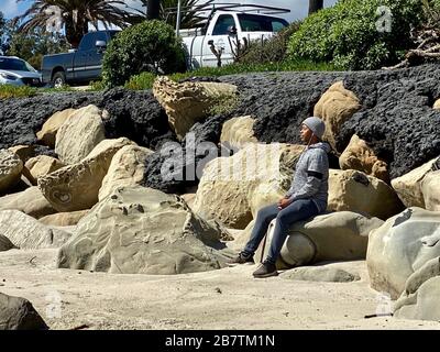 17 mars 2020, Montecito, Californie, U.S: Un homme profond dans la méditation comme les résidents du comté de Santa Barbara profiter d'une alternative à l'auto-isolation pendant la pandémie de virus Corona/Covid-19: Dans la nature sur la plage de papillons, en face de l'uber luxueux four Seasons Biltmore Hôtel à Montecito. Les personnes et les couples qui font du jogging, de la méditation et qui s'imprégnent du soleil n'ont aucun problème à maintenir les 6 pieds recommandés les uns des autres, et seulement quelques dizaines de personnes peuvent être vues à la fois largement réparties dans n'importe quelle zone donnée : Le total opposé des masses de rupture de ressort inondant FloridaÃs Clea Banque D'Images