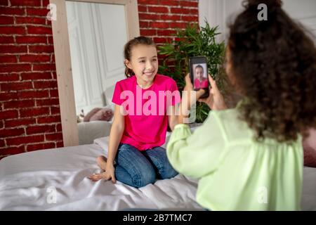 Une jeune fille aux cheveux bouclés qui fait un selfie de son ami Banque D'Images