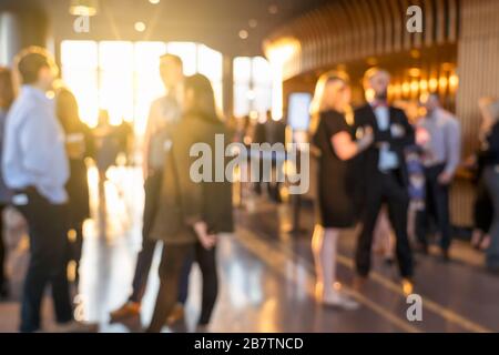 Photo floue foule de gens d'affaires non reconnaissables se tenant et parler ensemble dans un événement d'exposition à la salle de conférence, réunion et séminaire, vie Banque D'Images