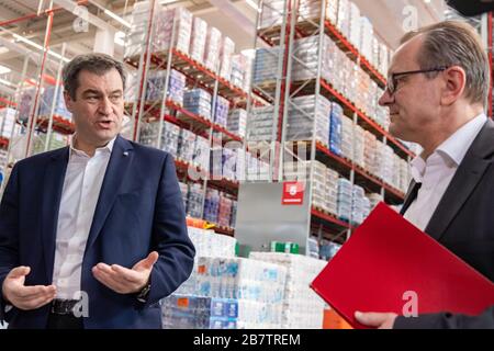 Eitting, Allemagne. 18 mars 2020. Markus Söder (l, CSU), ministre président de la Bavière, et Gustav König, responsable logistique de la région Sud, traversent les rangées d'étagères de l'entrepôt central REWE South. Crédit: Peter Knelove/dpa/Alay Live News Banque D'Images