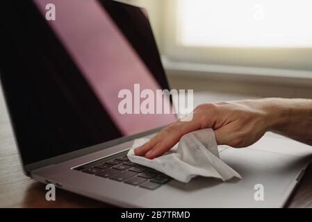 Nettoyage du clavier de l'ordinateur portable à l'aide d'un chiffon humide sur le lieu de travail. Hygiène personnelle Banque D'Images