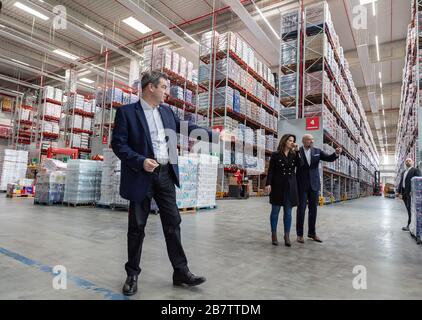 Eitting, Allemagne. 18 mars 2020. Markus Söder (l-r) (CSU), Premier ministre de la Bavière, Michaela Kaniber (CSU), ministre d'État de l'alimentation, de l'agriculture et des forêts, et Volker Hornsteiner, PDG de REWE Region South, traversent les rangées de rayons remplies à l'entrepôt central de REWE South. Crédit: Peter Knelove/dpa/Alay Live News Banque D'Images