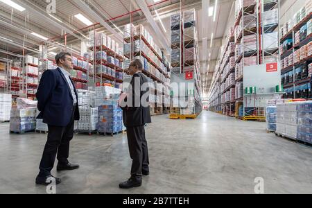 Eitting, Allemagne. 18 mars 2020. Markus Söder (l. CSU), le ministre président de la Bavière, et Gustav König, responsable logistique de la région Sud, parlent devant les rangées remplies d'étagères de l'entrepôt central de REWE South. Crédit: Peter Knelove/dpa/Alay Live News Banque D'Images