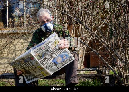 homme portant un masque facial comme protection contre l'infection du coronavirus lire le journal avec le rationnement alimentaire titre hongrie Banque D'Images