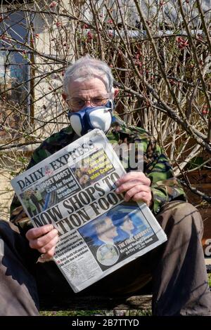 homme portant un masque facial comme protection contre l'infection du coronavirus lire le journal avec le rationnement alimentaire titre hongrie Banque D'Images