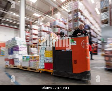 Eitting, Allemagne. 18 mars 2020. Un homme conduit un chariot élévateur chargé de marchandises par l'entrepôt central REWE Süd jusqu'au terminal de chargement. Crédit: Peter Knelove/dpa/Alay Live News Banque D'Images