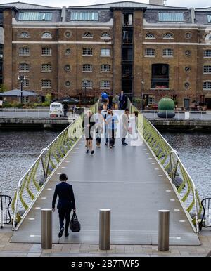 Les gens traversant le North Dock Footbridge de Canary Wharf à West India Quay. Londres, Royaume-Uni. Banque D'Images