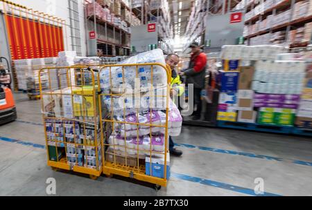 Eitting, Allemagne. 18 mars 2020. Un homme pousse des palettes roulantes avec des marchandises à travers l'entrepôt central REWE South jusqu'au terminal de chargement. Crédit: Peter Knelove/dpa/Alay Live News Banque D'Images