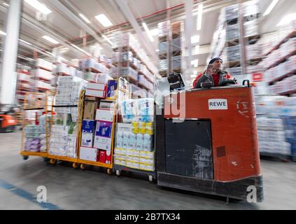 Eitting, Allemagne. 18 mars 2020. Un homme conduit un chariot élévateur chargé de marchandises par l'entrepôt central REWE Süd jusqu'au terminal de chargement. Crédit: Peter Knelove/dpa/Alay Live News Banque D'Images