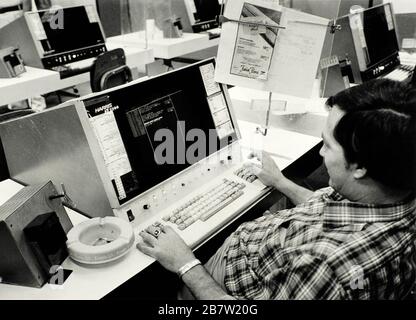 Austin, Texas États-Unis vers 1980: Employé de journal dactylographiant la publicité dactylographiant la copie dans le système informatique dans la salle de production d'arrière-boutique. © Bob Daemmrich Banque D'Images