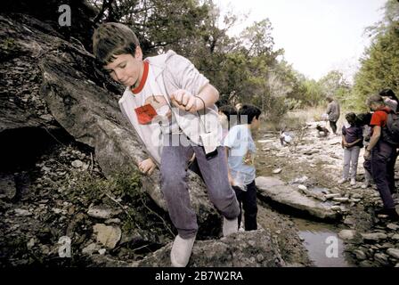 Bandera Texas USA: Les élèves de quatrième année qui ont fait de la randonnée dans le lit de la crique pendant une excursion scolaire au camp d'aventure en plein air dans le Texas Hill Country. ©Bob Daemmrich Banque D'Images