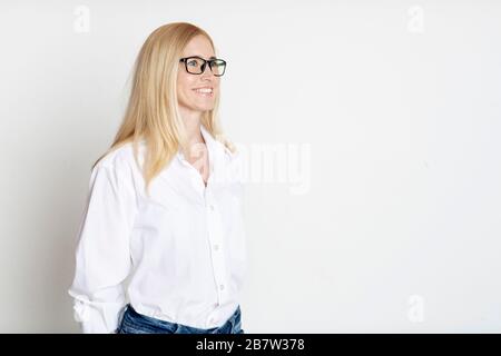 Portrait intérieur de la belle blonde dans des verres souriants Banque D'Images