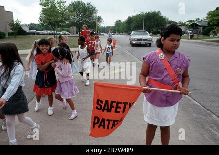 Austin Texas USA: Un membre de patrouille de sécurité d'école primaire aide les camarades de classe à traverser les rues en toute sécurité après l'école. ©Bob Daemmrich Banque D'Images