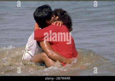 Un jeune couple embrasse en eau peu profonde près de la plage sur la côte du golfe du Texas. ©Bob Daemmrich Banque D'Images