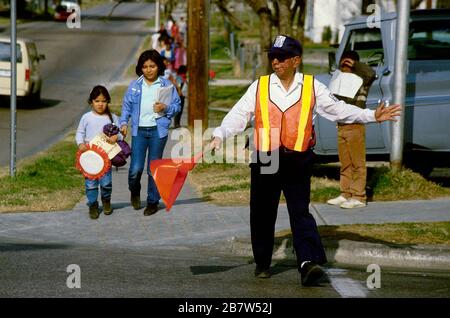 Austin, Texas États-Unis: Un garde-passage d'école pour adultes dirige la circulation et les piétons alors que les élèves et les parents quittent l'école primaire à la fin de la journée. ©Bob Daemmrich Banque D'Images