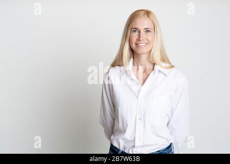 Portrait intérieur d'une belle dame blonde d'âge moyen souriante Banque D'Images