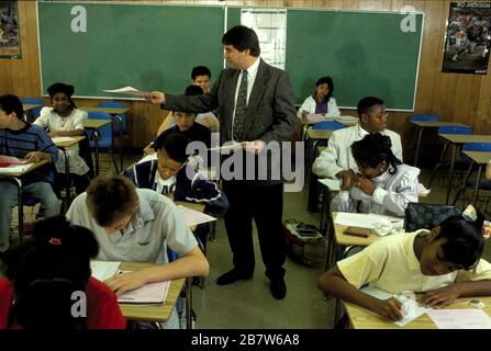 Austin Texas USA: Un enseignant de mathématiques junior de l'école secondaire, portant un pantalon de robe, une veste de sport et une cravate, teste ses élèves de 8th-année pendant la classe. Bob Daemmrich Banque D'Images