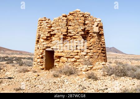 Les ruines d'un ancien moulin à vent en pierre utilisé pour lever l'eau souterraine pour l'irrigation près de Tuineje dans le centre de l'île des Canaries de Fuerteventura Banque D'Images