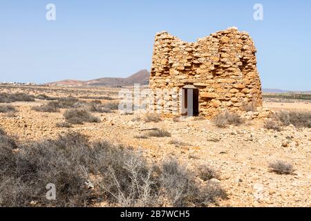 Les ruines d'un ancien moulin à vent en pierre utilisé pour lever l'eau souterraine pour l'irrigation près de Tuineje dans le centre de l'île des Canaries de Fuerteventura Banque D'Images