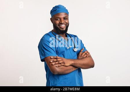 Jeune médecin noir souriant sur fond blanc Banque D'Images