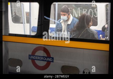 Un homme porte un masque de protection à bord d'un train de métro Jubilee Line, à Londres, alors que les navetteurs se rendent chez eux et que le public est invité à éviter tout contact social pour empêcher la propagation du coronavirus. Banque D'Images