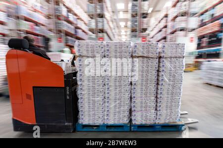 Eitting, Allemagne. 18 mars 2020. Un homme conduit un chariot élévateur chargé de papier toilette à travers l'entrepôt central REWE Süd jusqu'au terminal de chargement. Crédit: Peter Knelove/dpa/Alay Live News crédit: dpa Picture Alliance/Alay Live News Banque D'Images