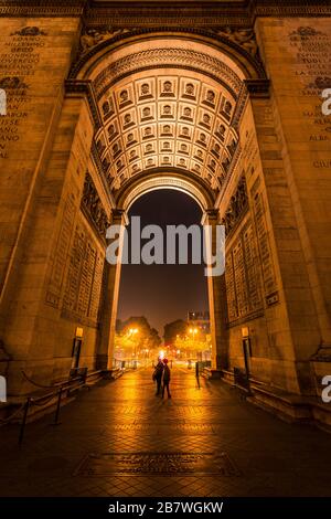 ARC de Triomphe à Paris la nuit vu de sous l'arc face à l'Avenue de Friedland avec deux touristes dans le centre. Paris, France. Banque D'Images