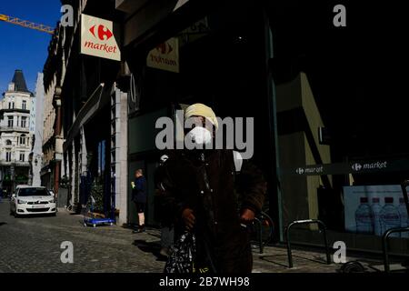 Bruxelles, Belgique. 18 mars 2020. Les personnes portant des masques de protection après une flambée du coronavirus font leur chemin dans le centre historique de Bruxelles. Crédit: ALEXANDROS MICHAILIDIS/Alay Live News Banque D'Images