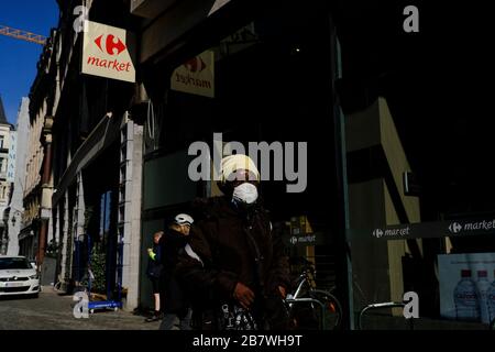Bruxelles, Belgique. 18 mars 2020. Les personnes portant des masques de protection après une flambée du coronavirus font leur chemin dans le centre historique de Bruxelles. Crédit: ALEXANDROS MICHAILIDIS/Alay Live News Banque D'Images