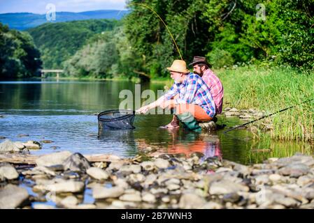 Journée en famille. Chanceux et qualifiés. Pêcher du poisson avec un ami. Les amis pêchent le poisson. Chers pêcheurs. Tourne et s'attaque. Bonne prise. Appât et crochet. Loisirs et loisirs. Bonne prise. Les hommes barbus pêchent. Banque D'Images