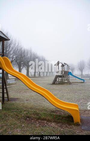 Toboggan pour enfants en brouillard d'automne sur une aire de jeux, Mondsee, Salzkammergut, Haute-Autriche, Autriche Banque D'Images