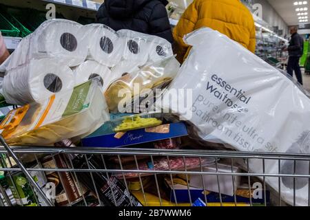 Londres, Royaume-Uni. 18 mars 2020. Pas de rationnement à waitrose, car un client se réserve suffisamment de toilettes pour durer quelques mois - malgré les promesses à la radio que les magasins avaient plein de nourriture, le Waitrose à Balham a des approvisionnements très bas en raison de l'achat de panique à cause de Coronavirus (Covid 19). Crédit: Guy Bell/Alay Live News Banque D'Images